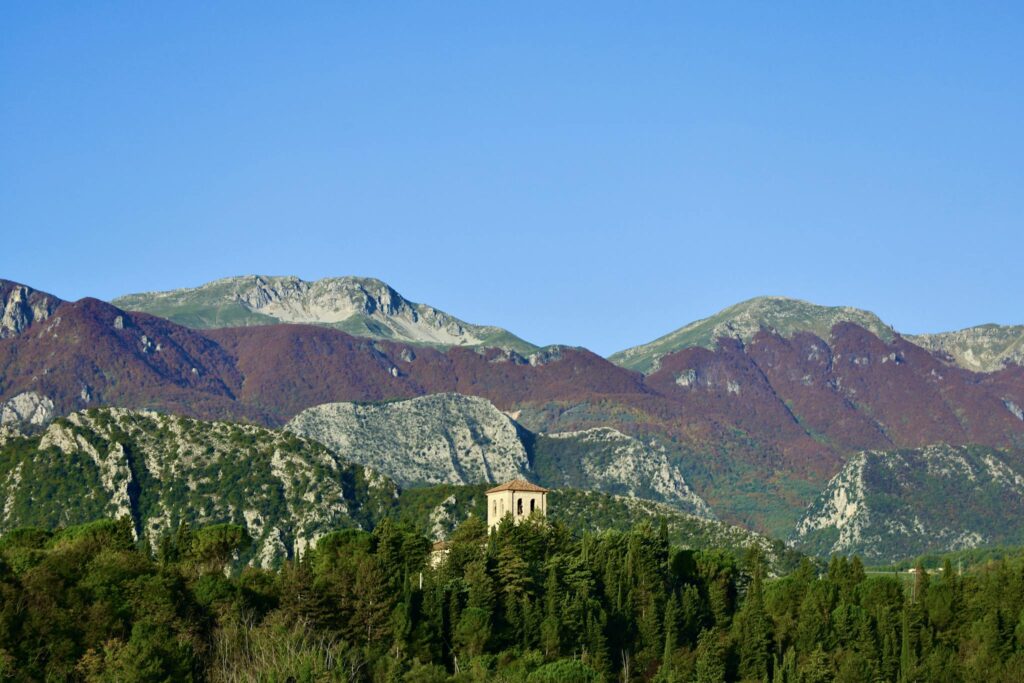 Explore a charming historic church nestled in the scenic Italian mountains. Perfect for travel enthusiasts.